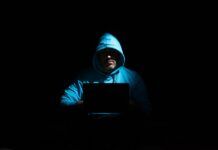 How To Report Digital Piracy & Illegal Streaming Sources a man sitting in the dark