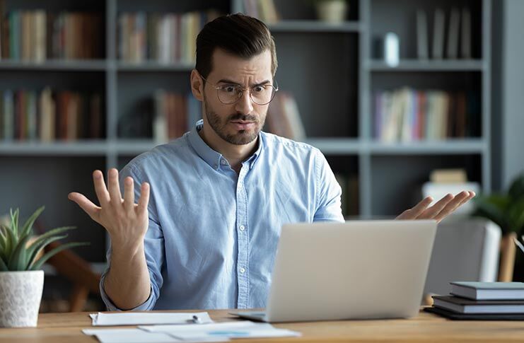 Unhappy,Young,Caucasian,Male,Worker,In,Glasses,Look,At,Laptop Unhappy young male in glasses looks shocked by problem on laptop screen..