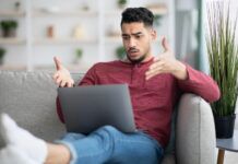 Beware of Illegal Sources: Chitram TV Young man throws his hands up and looks frustrated after visiting an illegal streaming service online on his laptop