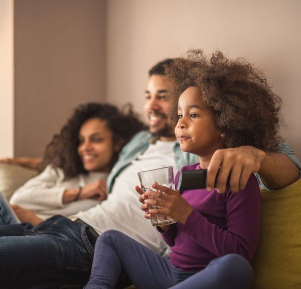 100FreeHero_sq Young family with child watching TV on sofa