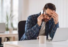 Debunking the 8 Most Common Myths About Digital Piracy and Illegal Streaming Man on the phone worried after visiting an illegal streaming website on his computer