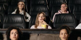 We Ran the IMDB Top 250 Through the Bechdel Test. 95 Pass, 155 Fail Moviegoers watching a film in a theater, representing popular and top-rated movies.