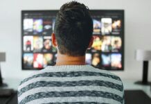 How AI is Used to Both Enable and Combat Illegal Streaming Person browsing movies and TV shows on a streaming service using a smart TV.