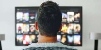 How AI is Used to Both Enable and Combat Illegal Streaming Person browsing movies and TV shows on a streaming service using a smart TV.