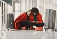 Is an Unsecured Public Wi-Fi Network Safe for Streaming? Two happy people in red waiting in airport with luggage sharing wifi on mobile device