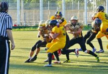 How to Safely Watch Every 2025–26 NFL Game people playing american football with referee on the field during daytime.